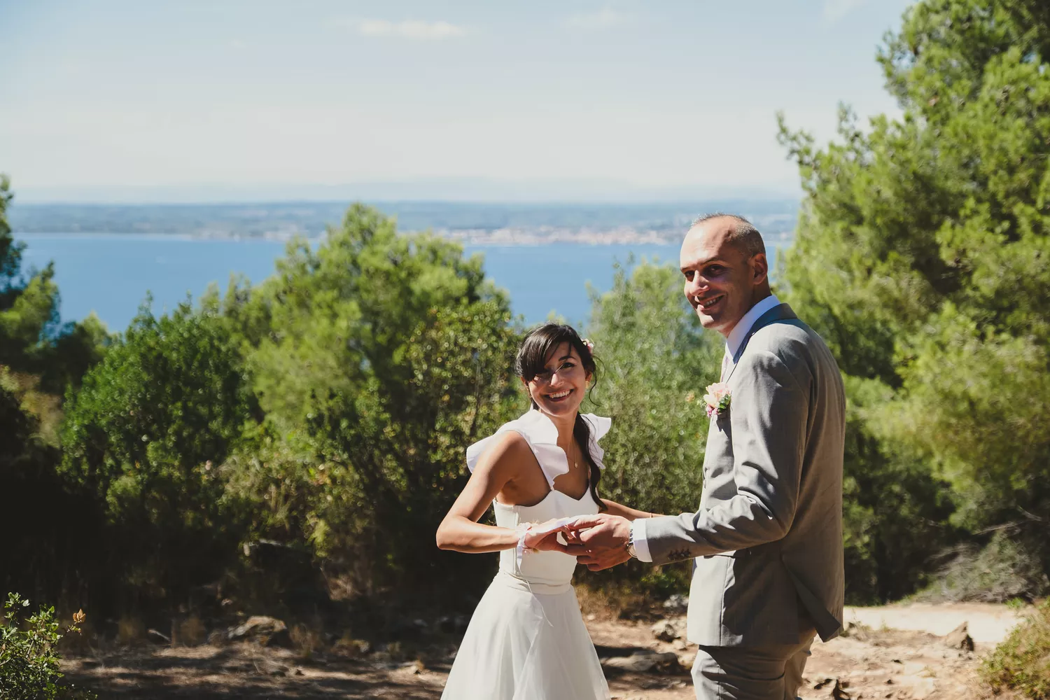 couple de mariés se tenant la main et rigolant lors de leur séance couple de mariage dans un parc