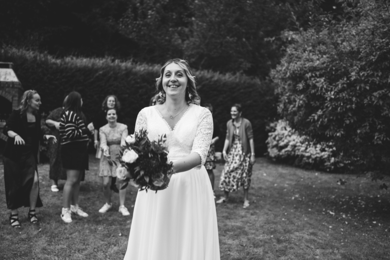 mariée de normandie se tenant prête à lancer son bouquet