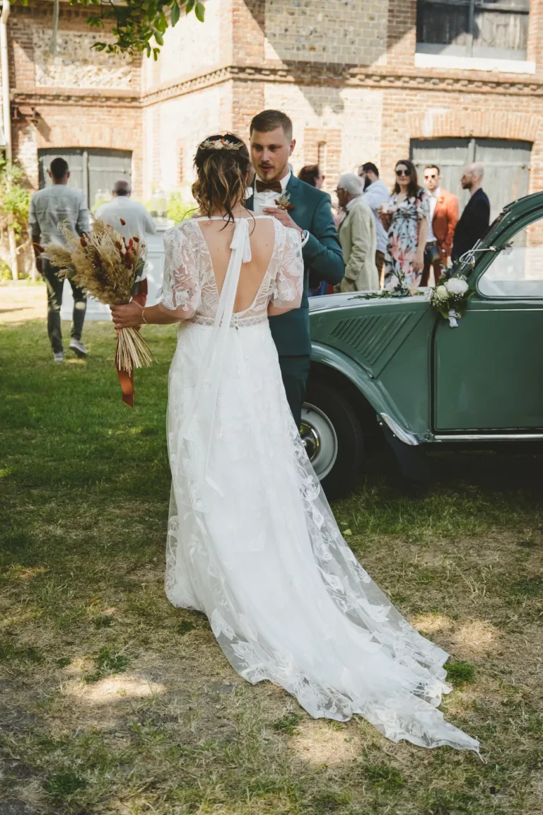 mariée de dos qui discute avec son mari lors du vin d'honneur de leur mariage bohème en normandie