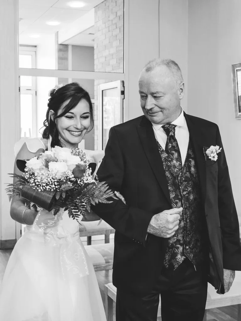 papa de la mariée qui regarde fièrement sa fille en l'emmenant devant le maire lors de son mariage