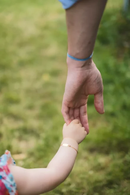 la main d'un papa tenant celle de sa fille