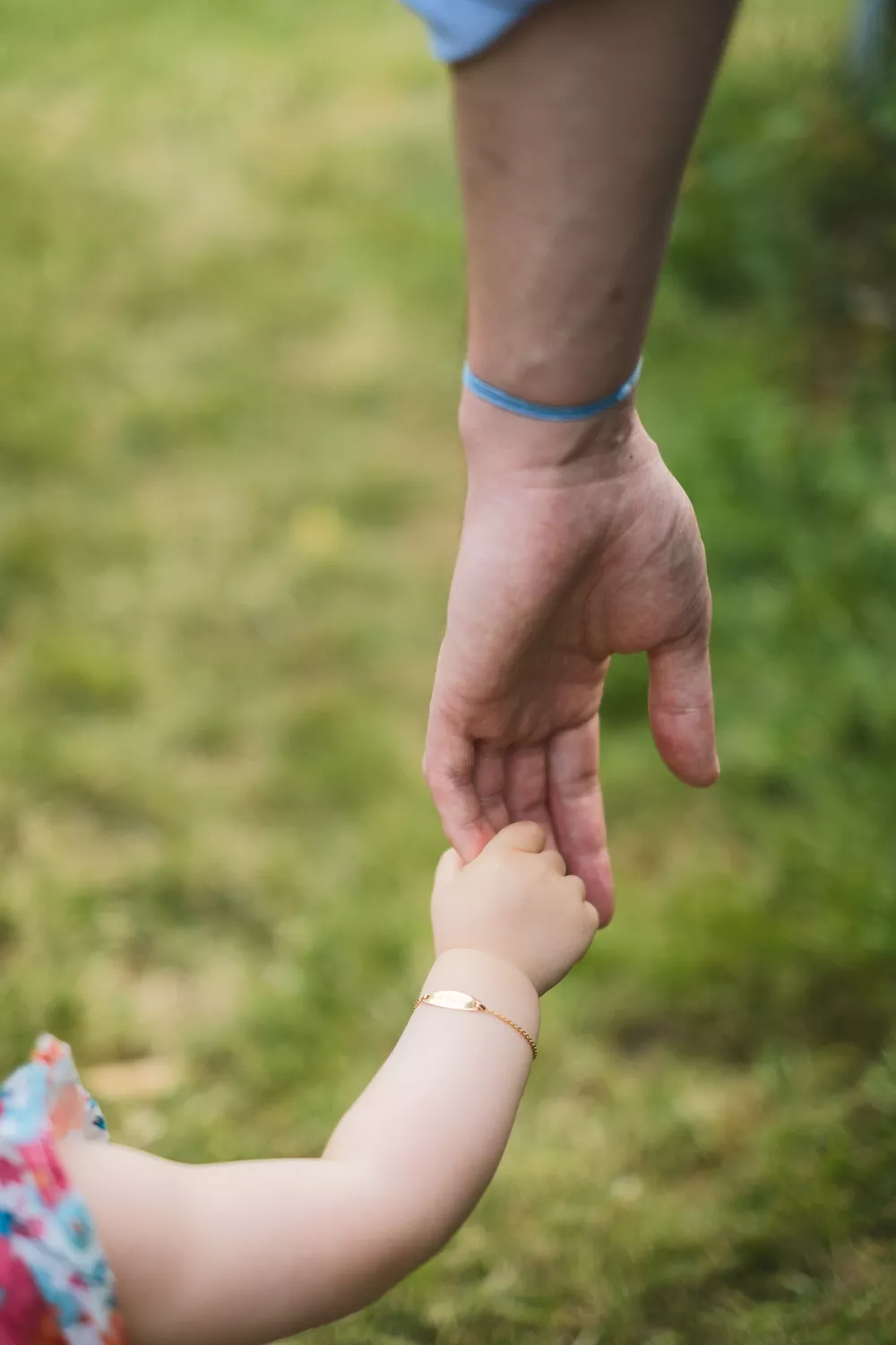 la main d'un papa tenant celle de sa fille