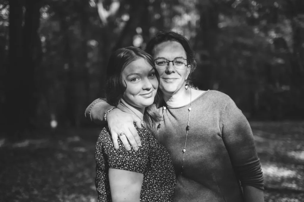 photographie de famille entre mère et fille se tenant par l'épaule dans la forêt
