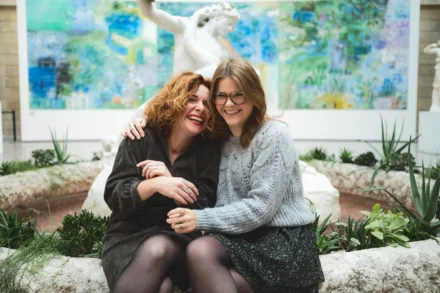 photo de famille de deux soeurs éclatant de rire dans un musée