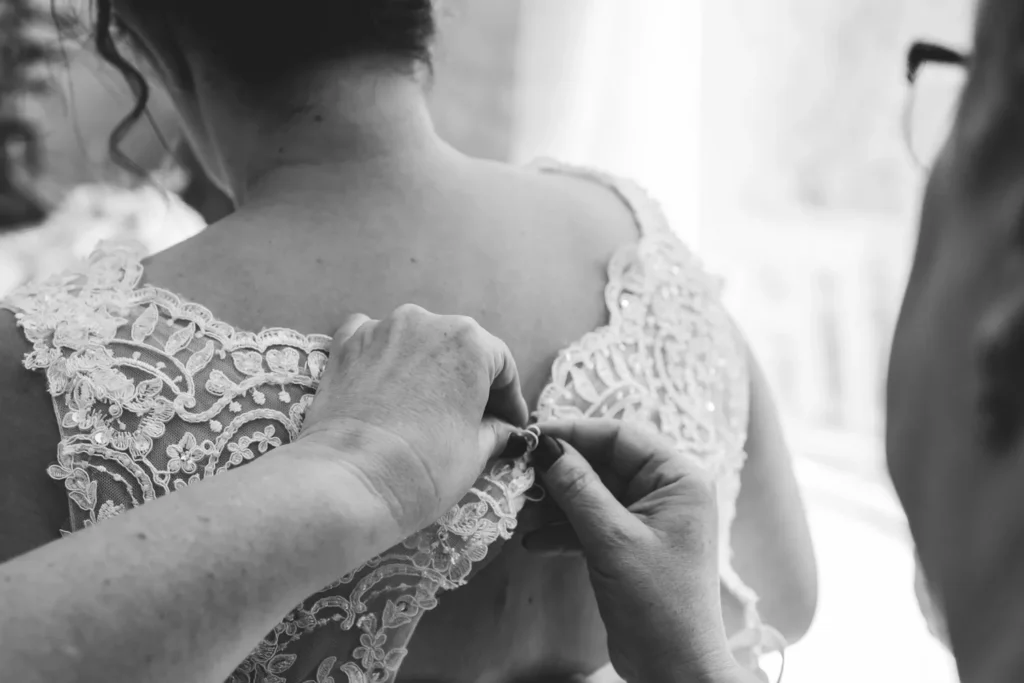 boutonnage de robe de mariée lors des préparatifs de son mariage en normandie