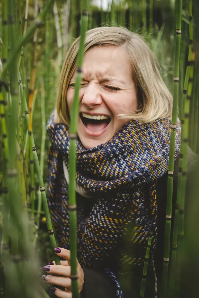 portrait d'une jeune femme éclatant de rire au milieu des bambous en normandie