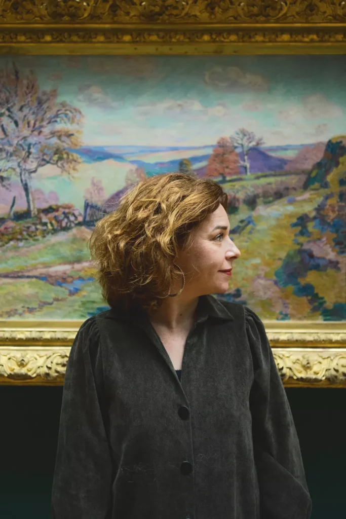 portrait d'une jeune femme de profil devant un tableau au musée en normandie