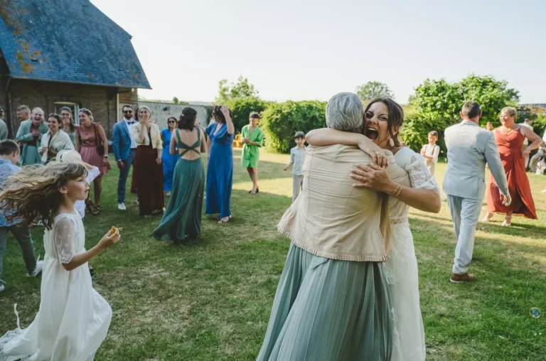 mariée serrant dans les bras son invitée qui a reçu le bouquet lors de son mariage en ile de france