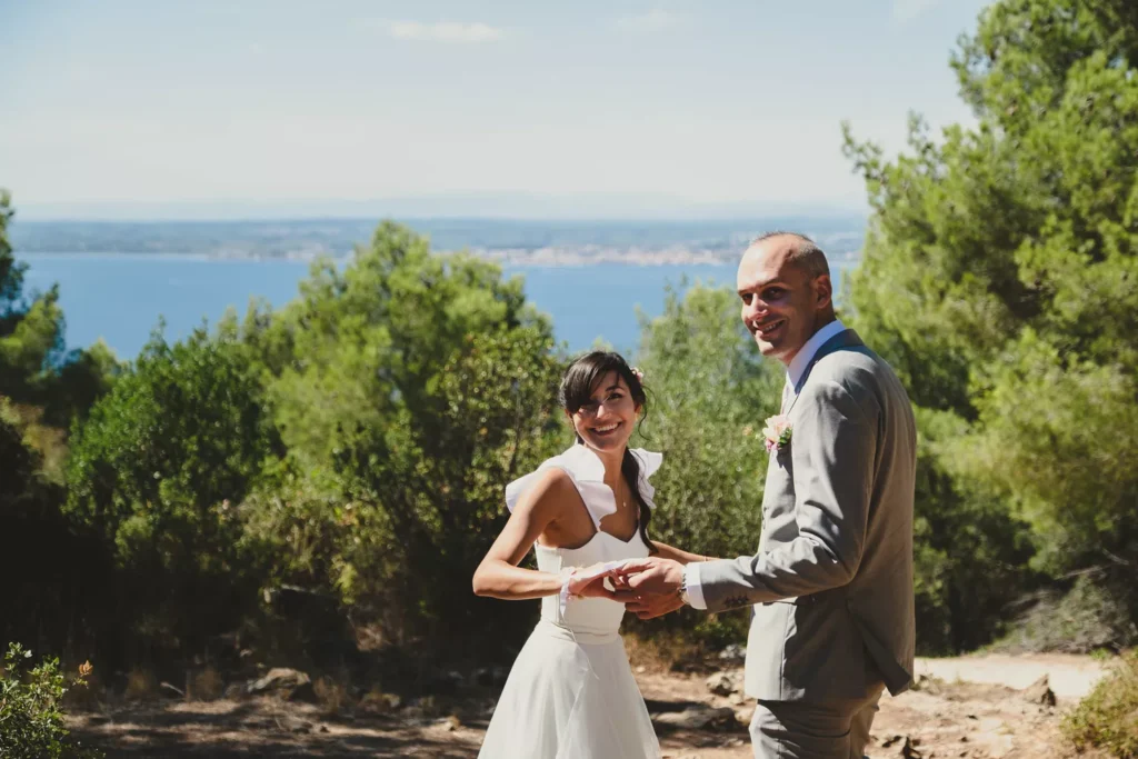 couple de jeunes mariés se tenant par la main et rigolant en regardant leur photographe de mariage à rouen