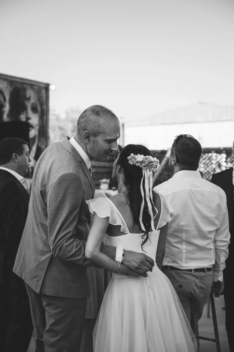 couple de jeunes mariés se murmurant à l'oreille lors de leur vin d'honneur par une photographe de mariage en yvelines