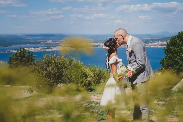 couple de mariés s'embrassant avec la mer en arrière plan par un photographe mariage oise