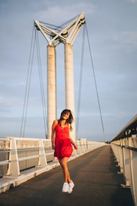 portrait dynamique sur un pont d'une femme qui saute et danse