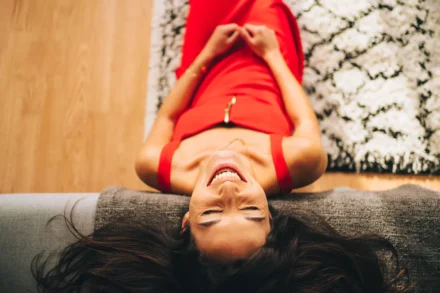 jeune femme éclatant de rire la tête sur un canapé